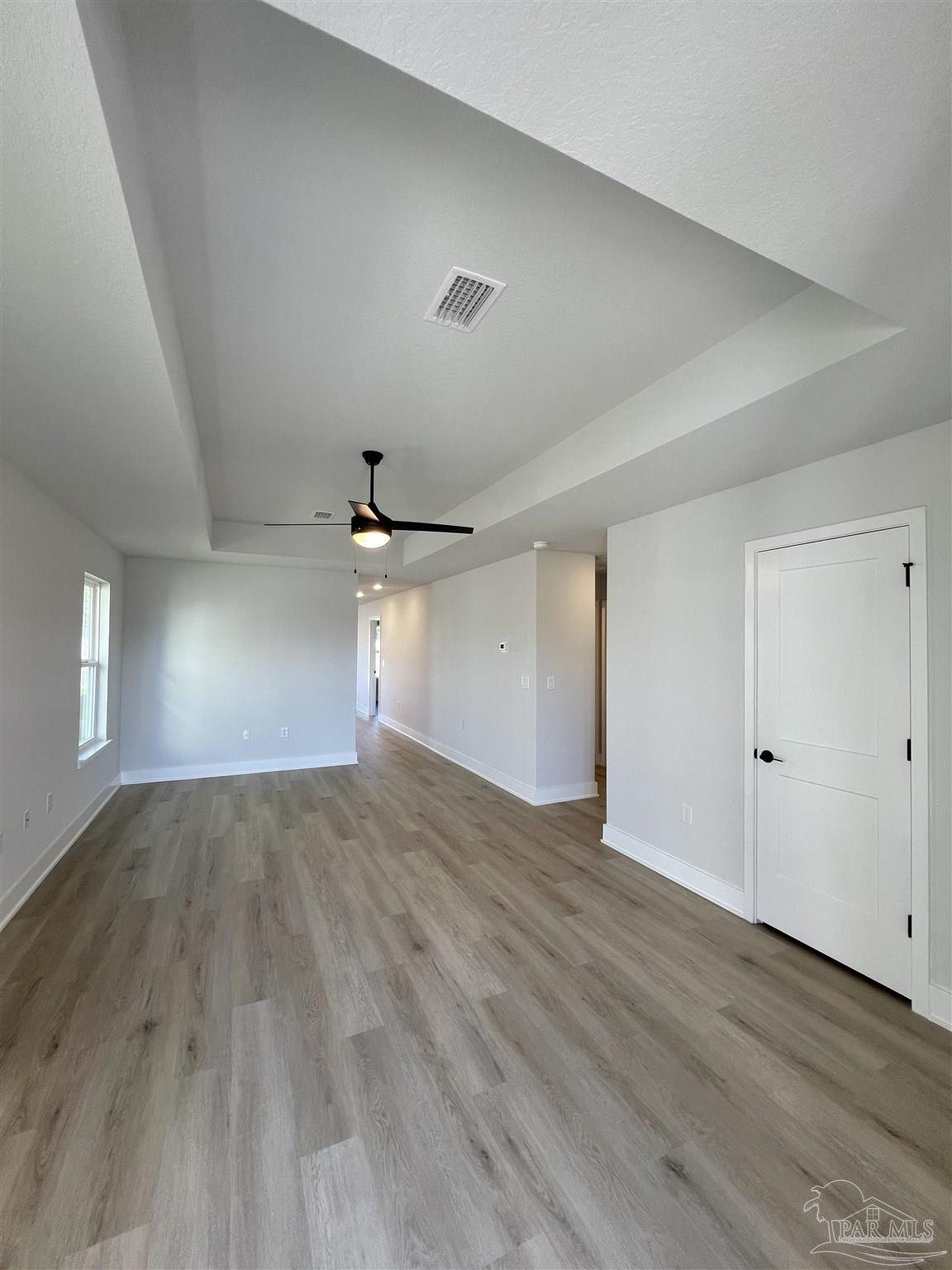 3327 Bliss Lane, Unit 12E Cantonment, FL 32533 - Photo 2 of 15 an empty room with wooden floor and windows