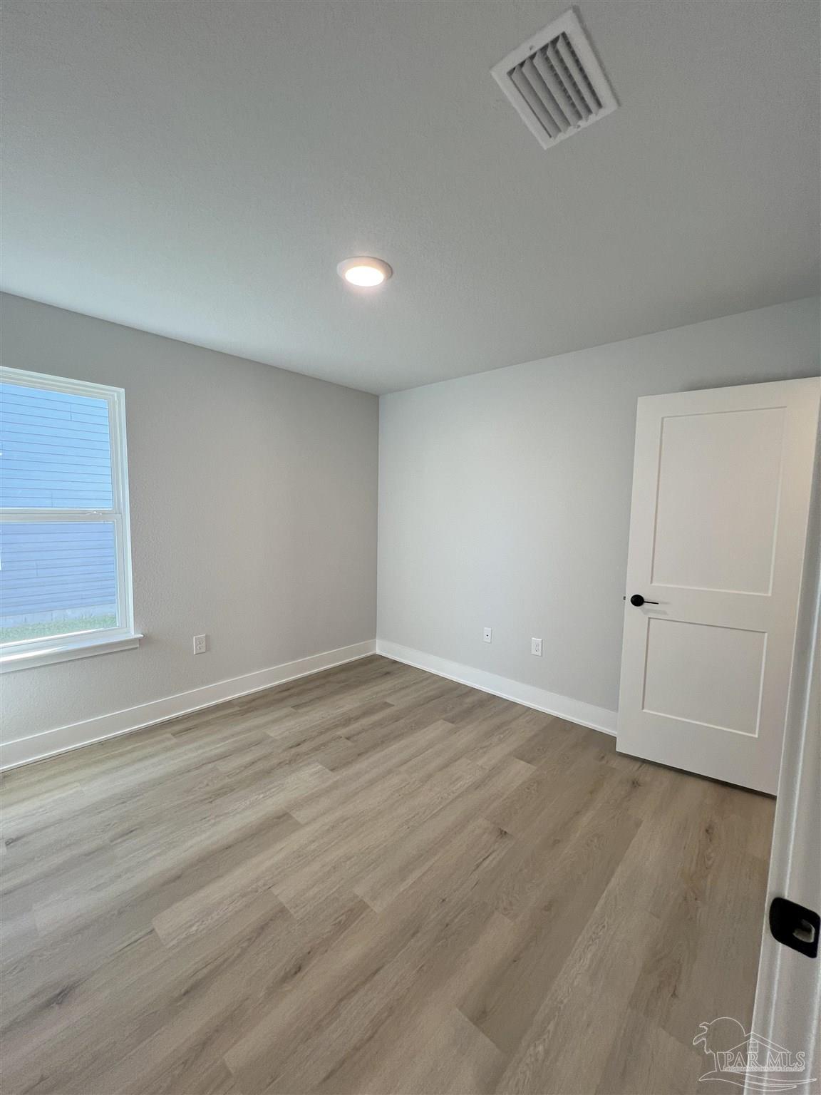 3327 Bliss Lane, Unit 12E Cantonment, FL 32533 - Photo 4 of 15 wooden floor in an empty room
