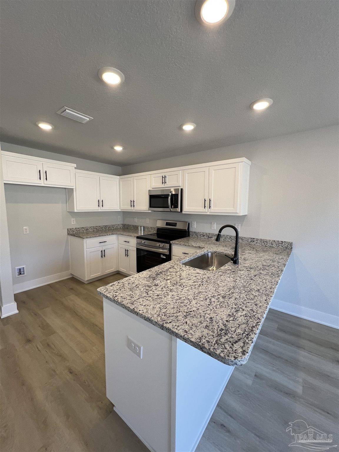 3327 Bliss Lane, Unit 12E Cantonment, FL 32533 - Photo 8 of 15 a kitchen with stainless steel appliances granite countertop a sink stove and cabinets