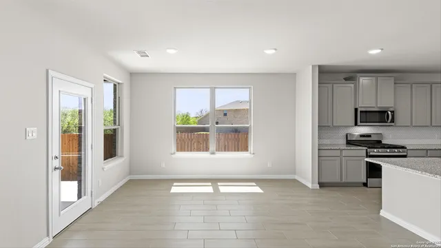 an empty room with wooden floor and ceiling fan