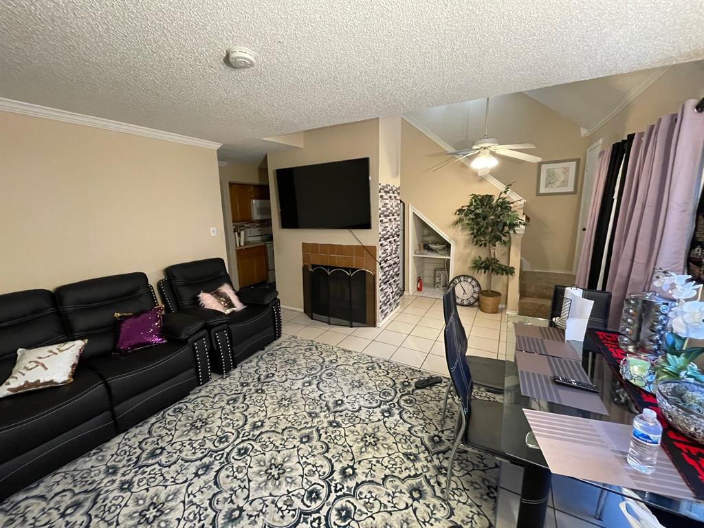 9809 Walnut Street, Unit 208 Dallas, TX 75243 - Photo 1 of 1 a living room with furniture a flat screen tv and a fireplace