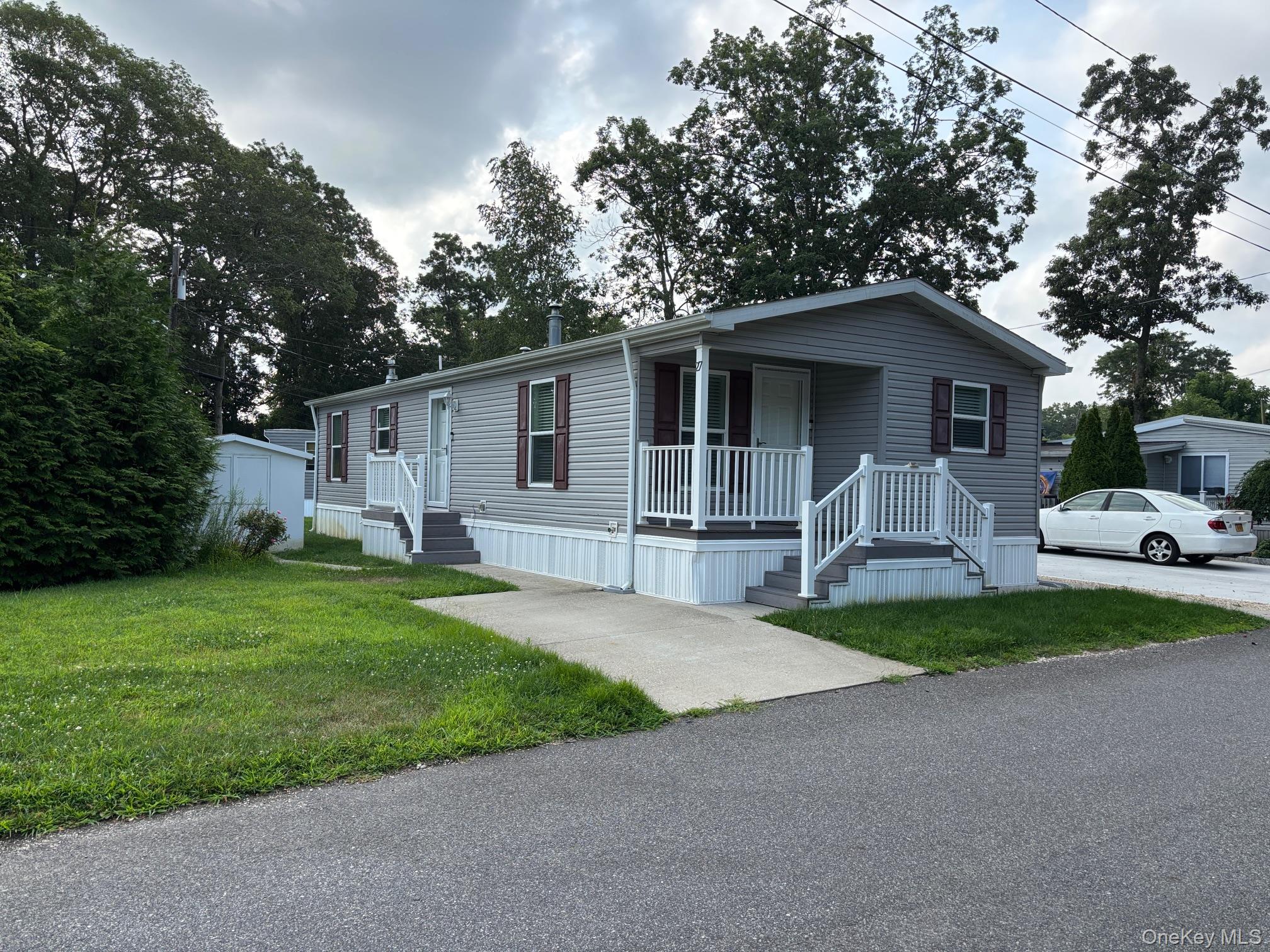 61 Forge Road, Unit 27 Riverhead, NY 11901 - Photo 1 of 1 a front view of house with yard and green space