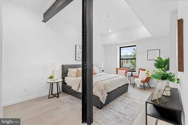 a bedroom with a bed chandelier and a window