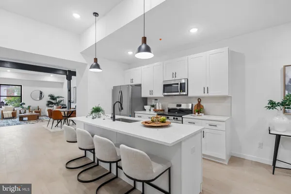 a kitchen with stainless steel appliances a stove a table and chairs in it