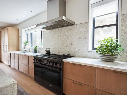 a kitchen with kitchen island a counter space a sink a stove and a dining table with wooden floor