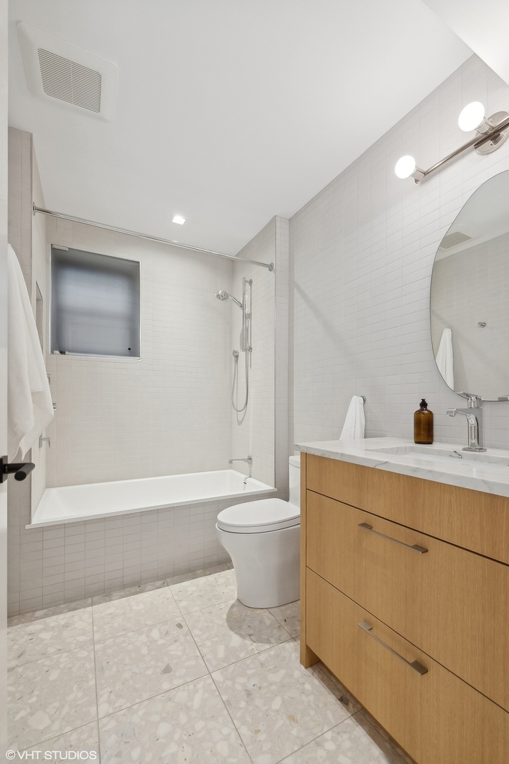 2039 North Humboldt Boulevard Chicago, IL 60647 - Photo 44 of 49 a bathroom with a toilet a sink a mirror a bathtub and vanity