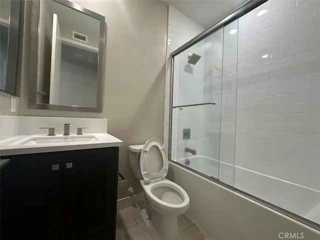 a bathroom with a sink mirror toilet and shower
