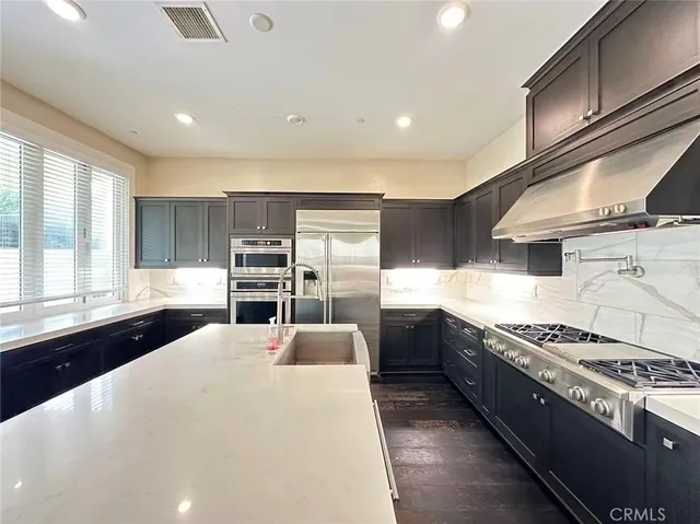a kitchen with stainless steel appliances kitchen island granite countertop a stove and a sink