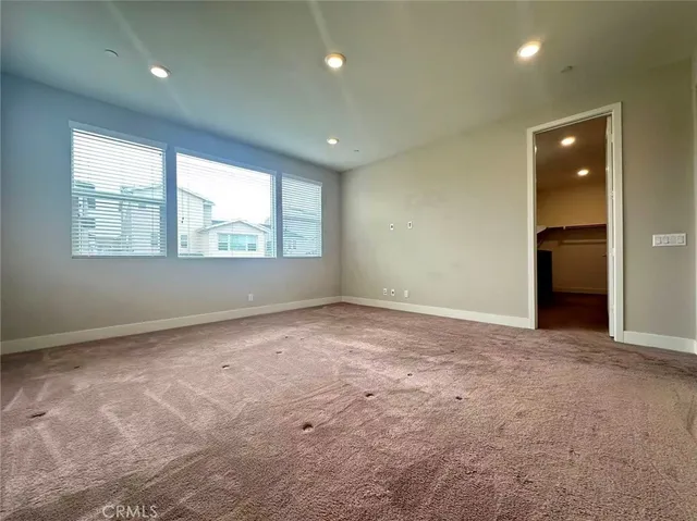 an empty room with windows and closet