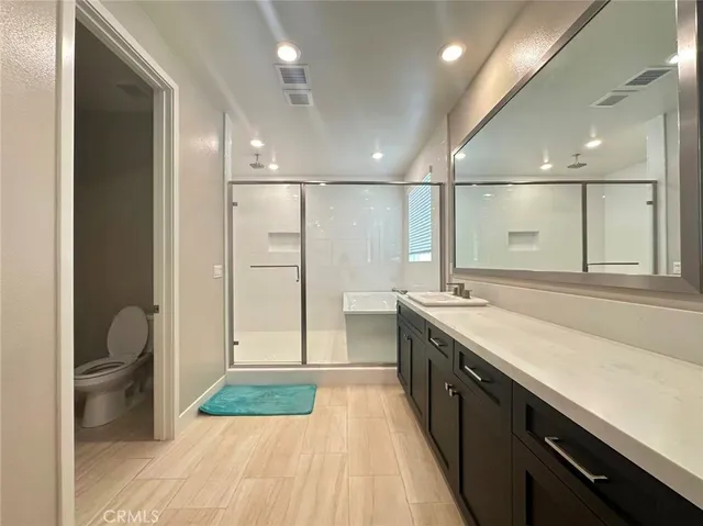 a bathroom with a sink a toilet a mirror and vanity