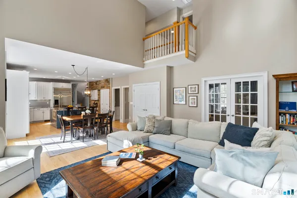a living room with furniture a table and kitchen view