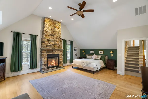 a spacious bedroom with a bed and a fireplace