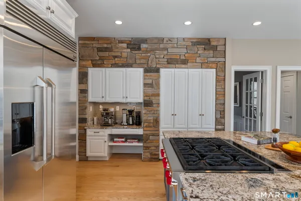a kitchen with stainless steel appliances granite countertop a refrigerator and a stove