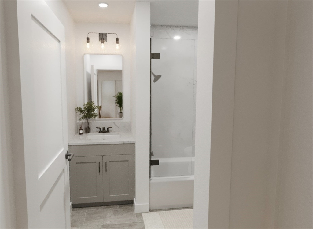270 Talbot Avenue, Unit 302 Boston, MA 02124 - Photo 9 of 13 a bathroom with a bathtub a sink a vanity and a mirror