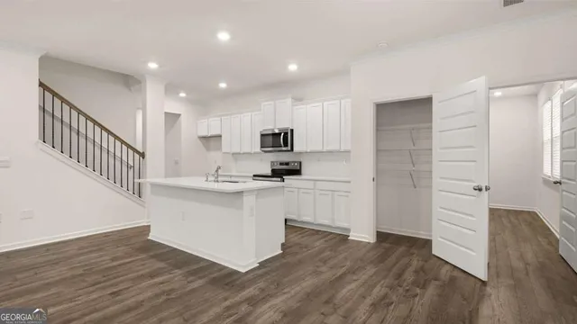 a kitchen with a refrigerator and a stove top oven