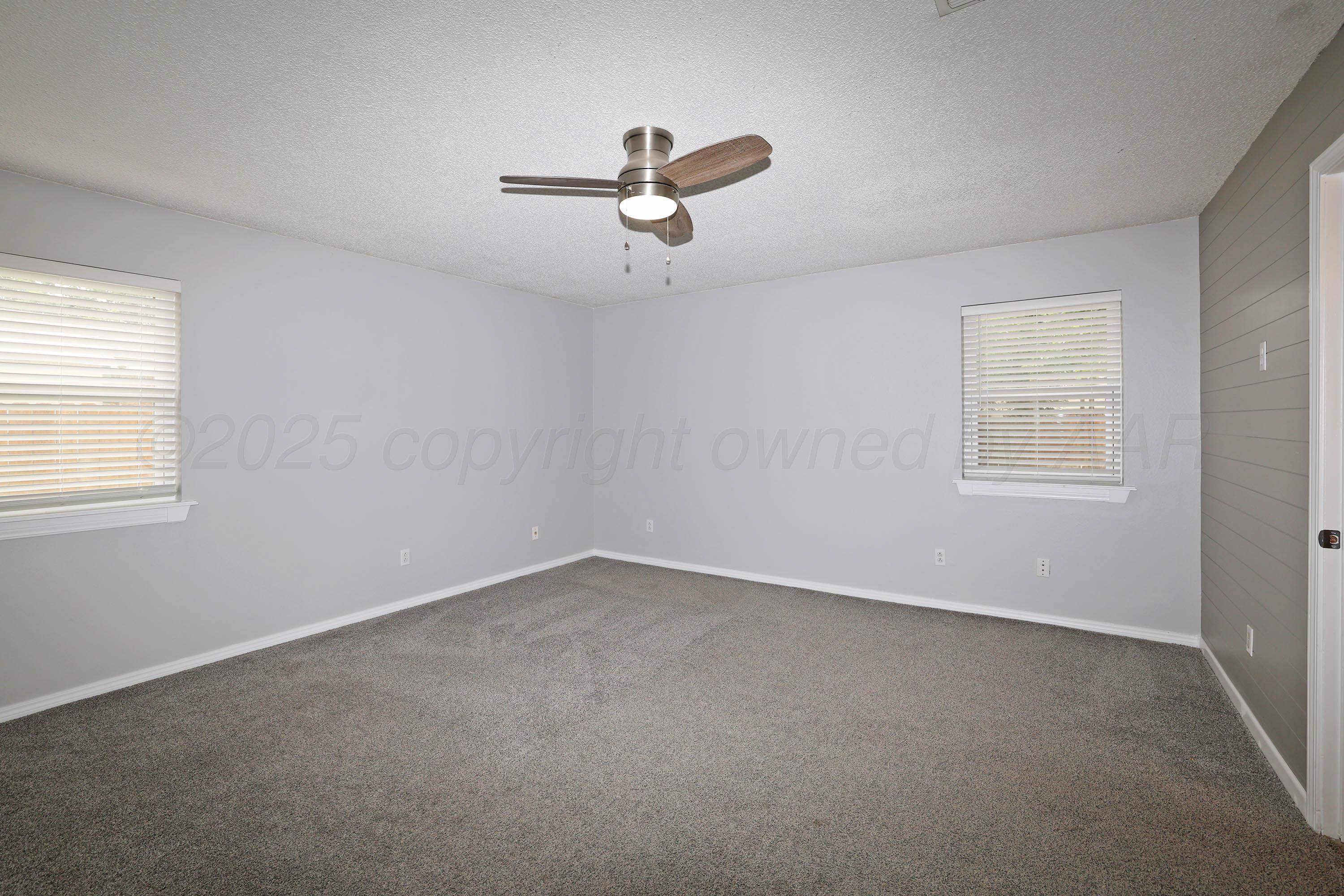 7426 Jameson Drive Amarillo, TX 79121 - Photo 19 of 38 an empty room with a window and a ceiling fan