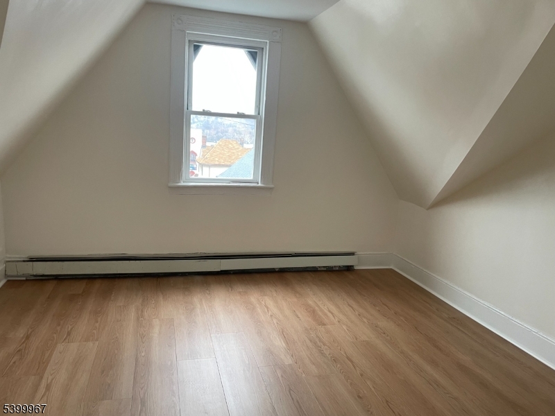 87 Butler Street Paterson, NJ 07524 - Photo 2 of 3 an empty room with wooden floor and windows