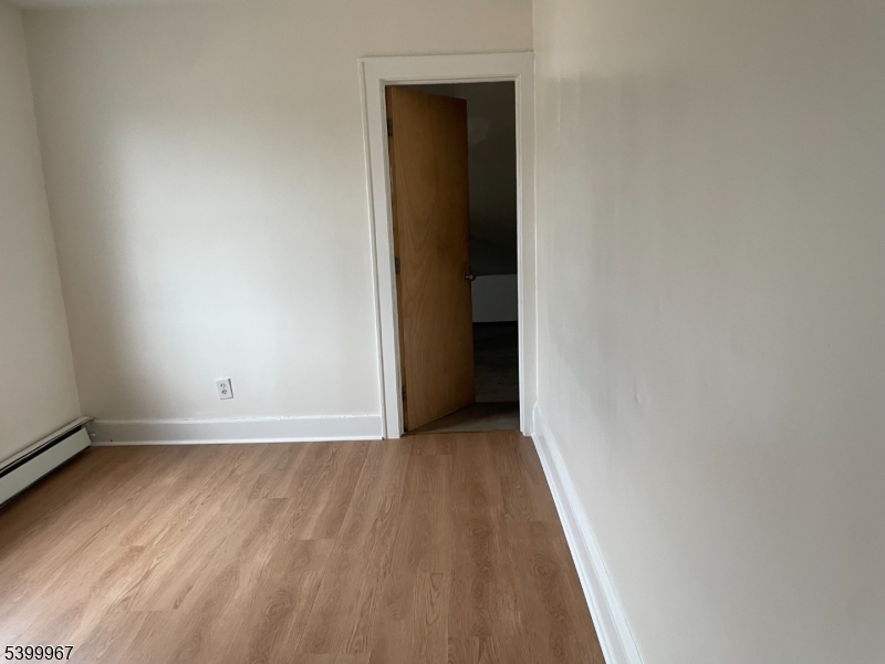 87 Butler Street Paterson, NJ 07524 - Photo 3 of 3 a view of an empty room with wooden floor