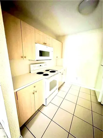 a kitchen with granite countertop a sink and a stove top oven