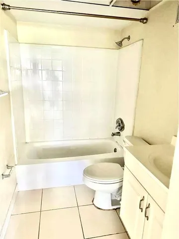 a bathroom with a granite countertop bathtub toilet and sink