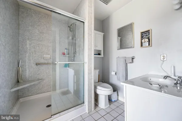a spacious bathroom with a granite countertop sink a mirror a vanity and a window