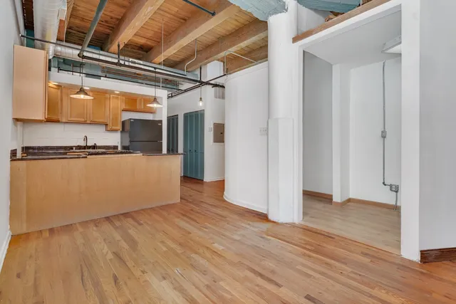 a view of a kitchen with wooden floor and a sink