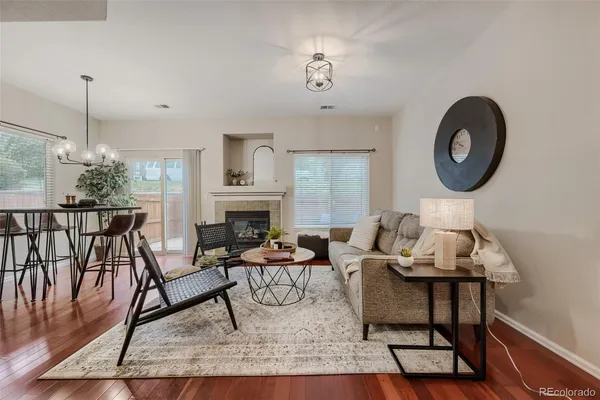 a living room with furniture a fireplace and a chandelier