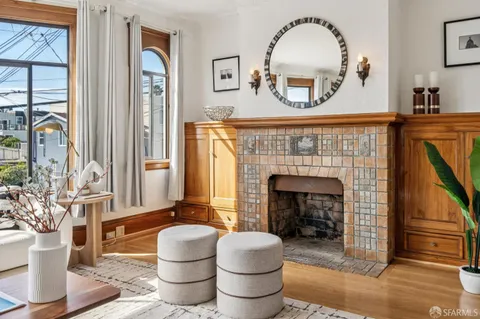 a living room with furniture a fireplace and potted plants