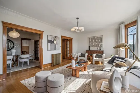 a living room with fireplace furniture and a large window