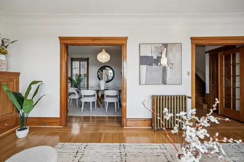 a dining room with furniture a large window and wooden floor