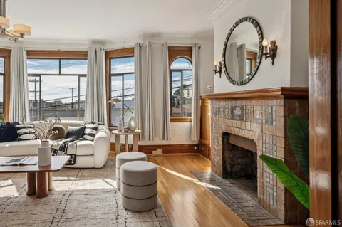 a living room with furniture a fireplace and a large window