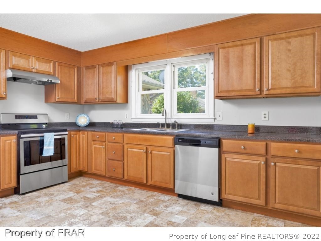 901 Ruton Court Fayetteville, NC 28303 - Photo 4 of 7 a kitchen with stainless steel appliances granite countertop a stove a sink and a microwave