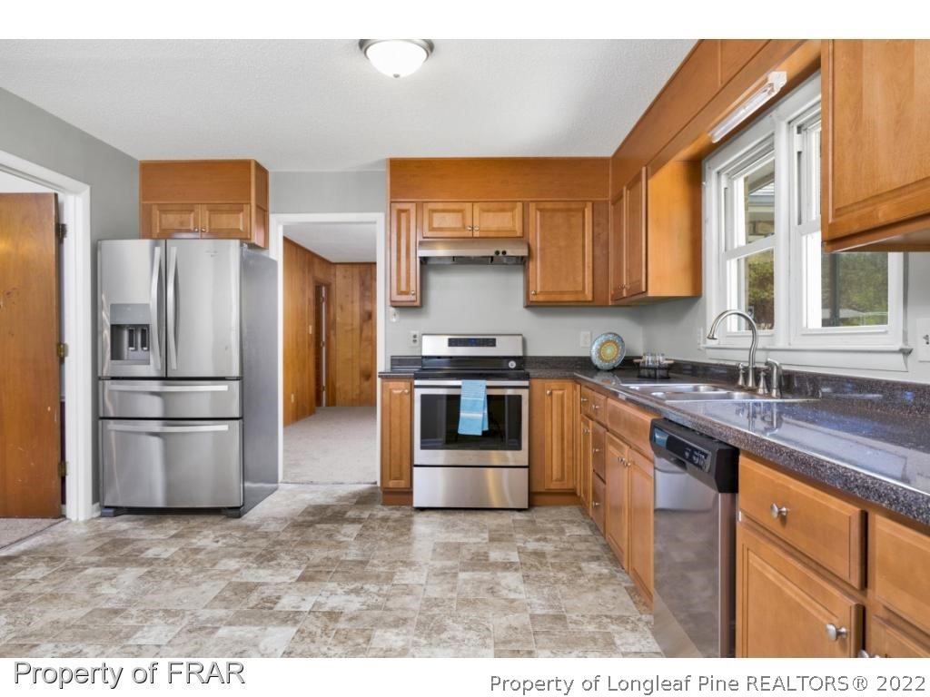 901 Ruton Court Fayetteville, NC 28303 - Photo 5 of 7 a kitchen with stainless steel appliances granite countertop a refrigerator a stove and a sink