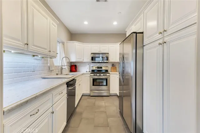a kitchen with stainless steel appliances granite countertop a refrigerator and a stove