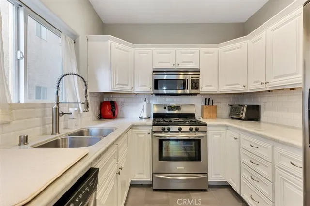 a kitchen with white cabinets stainless steel appliances and sink