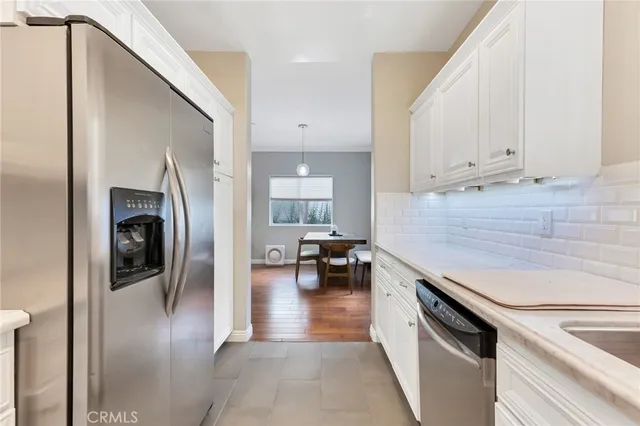 a kitchen with a refrigerator and white cabinets