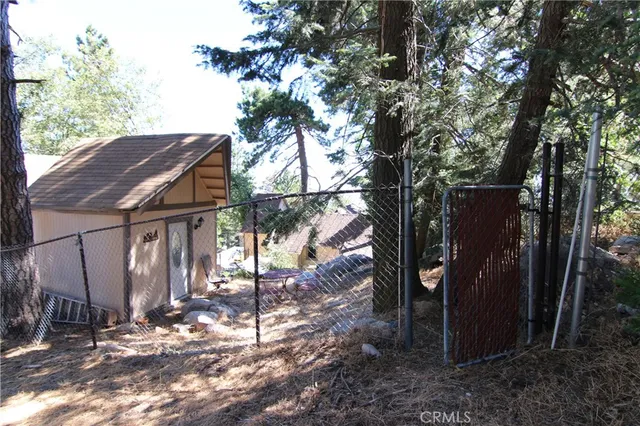a view of a house with a small yard and wooden fence