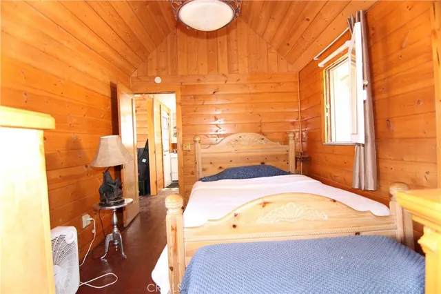 a spacious bedroom with a bed and wooden floor