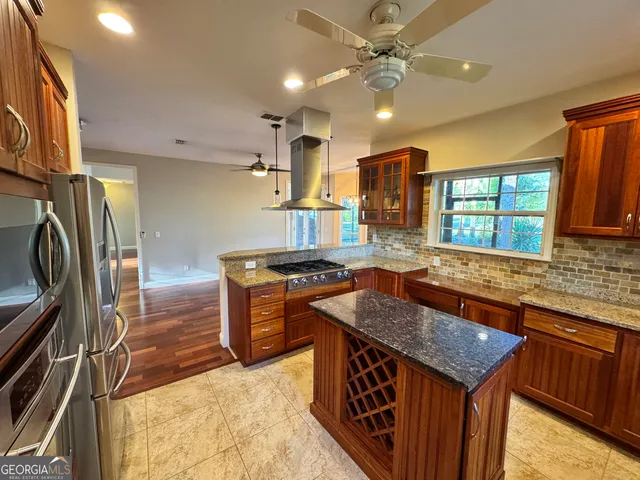 a view of a hallway with wooden floor and a bathroom