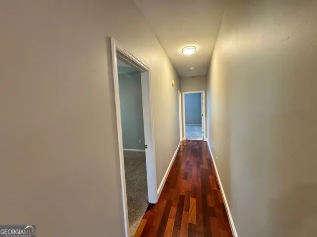an empty room with a chandelier fan and windows