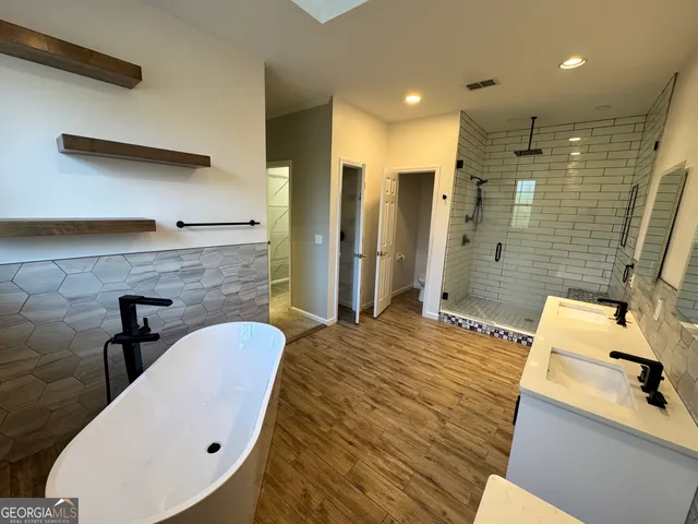 a spacious bathroom with a sink a mirror and a bathtub