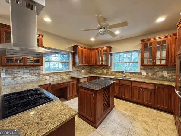 a kitchen with stainless steel appliances granite countertop a stove refrigerator and cabinets