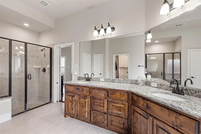 a bathroom with double vanity sinks and a shower