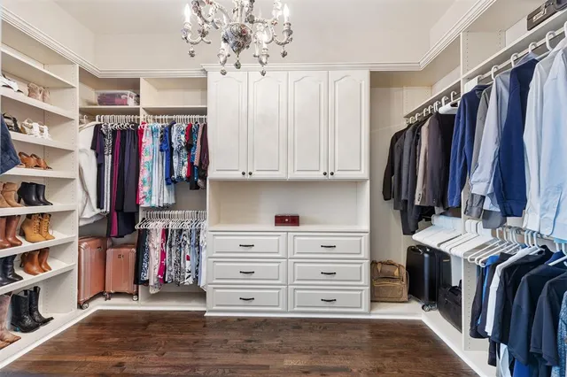 a view of walk in closet with clothes and shoes