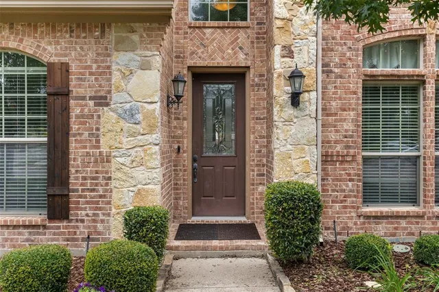 a stone house with potted plants in front of door