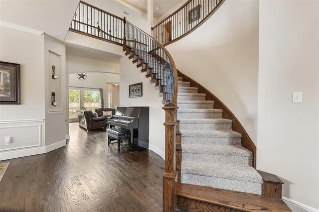 a living room with couches and dining table with wooden floor