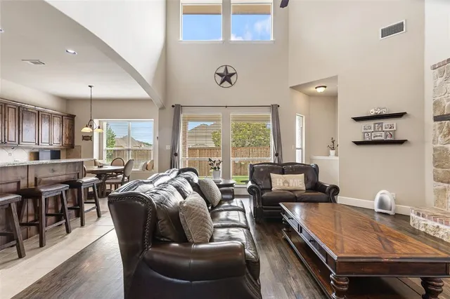 a living room with furniture two window and wooden floor