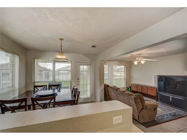 a living room with furniture a chandelier and a large window
