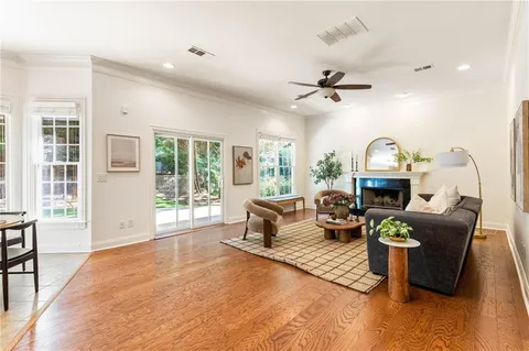 a living room with furniture a fireplace and a floor to ceiling window