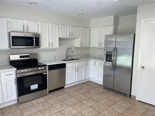 a stove top oven sitting inside of a kitchen